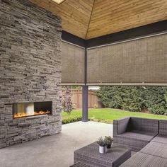 an outdoor living area with couches and a fire place