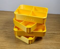 three yellow plastic containers stacked on top of each other