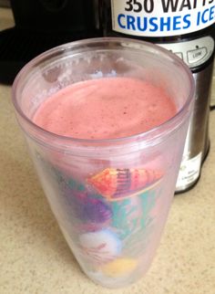 a plastic cup filled with pink liquid on top of a counter