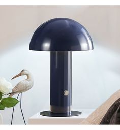 a blue lamp sitting on top of a table next to a white flower