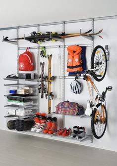 an organized bike rack with skis, snowboards and helmets on the top shelf