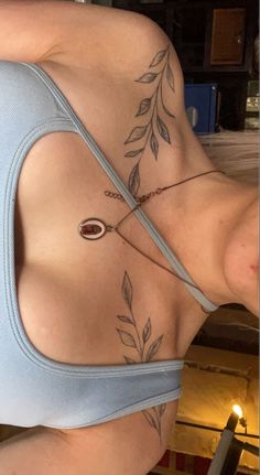 a woman with tattoos on her stomach wearing a bra