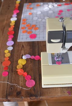 a sewing machine sitting on top of a wooden table with confetti scattered around it