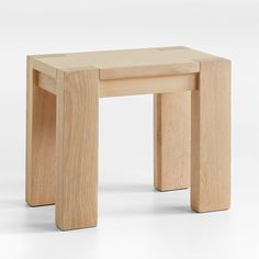 a small wooden stool sitting on top of a white floor