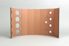 an open cardboard box with holes and circles on the inside is shown in front of a white background