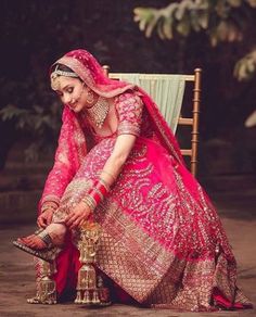 a woman sitting on top of a chair in a pink dress