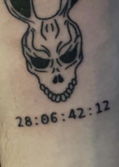 a black and white tattoo with a skull in the middle on someone's arm