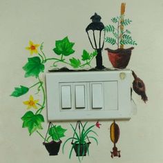 an electrical outlet with flowers and plants painted on the wall next to it is a light switch