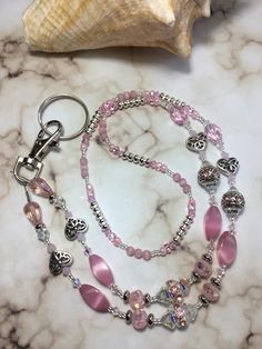 My Newest Creation Customer Inspired Custom Order. Made With, 4mm Clear AB, Pink, Pink Matte, 6mm, 10mm Clear Bicone AB Swarovski Crystals, 1 inch Long 4mm Round Matte Pink Cats Eye Stones, Faceted Pink Glass Crystals, Beautiful Fancy Pink/Silver Rhinestone Spacers, Czech Glass, Silver Plated Fancy Tube Spacers And Rondelles, Filigree Butterfly Heart Spacers With 14mm Silver Plated Lobster Clasps With Clear/Silver Stretch Cords To Accommodate All Type Eyeglasses. For A Lanyard/Badge Holder I Use A 1.5 Silver Plated Large Lobster Clasps With Wring Pictured. CRYSTAL also known as Clear Quartz, is the "Stone that brings the Energy of the Stars to the Soul."  It aligns human energies - thoughts, emotions and consciousness - to the energies of the Universe bringing connection and communication, Pink Rhinestone Round Bead Jewelry, Pink Glass Jewelry With Faceted Beads, Pink Glass Jewelry For Jewelry Making, Pink Glass Round Jewelry, Pink Round Glass Jewelry, Pink Beaded Crystal Jewelry, Heart-shaped Pink Glass Jewelry, Pink Heart-shaped Glass Jewelry, Pink Spiritual