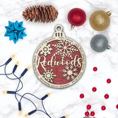 a christmas ornament with the word redwood on it surrounded by holiday decorations