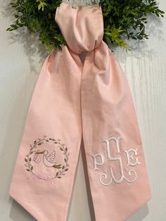 two pink scarfs with embroidered monogramming on them