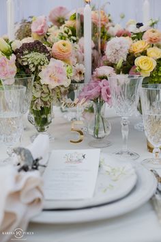 the table is set with flowers, candles and napkins for an elegant wedding reception