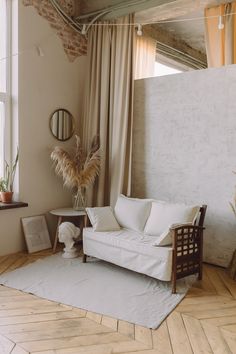 a living room with a white couch and wooden flooring next to a large window