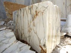 a large marble block sitting on top of a pile of rubble next to a wall