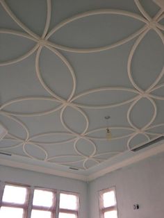 an empty room with three windows and a ceiling made out of white circles on the ceiling