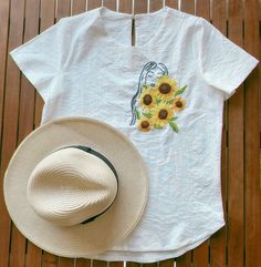 White t-shirt blouse with hand embroidered sunflower girl.  Simple yet elegant flower design Fall casually  Suitable for many occasions Go well with jeans/shorts for casual wear as well as under blazer/suit for more formal business attire Care Instruction: - Hand wash or gentle cold machine wash - Due to the delicate nature of hand embroidery we recommend washing in a laundry bag to prevent the embroidery from catching on anything during the wash - Mild detergent  - Wash inside out - Air dry only  - Dry clean is not recommended  - Iron inside out   - Do not iron directly on top of the embroidery  - Do not bleach  Please note - Refunds or exchange will not be provided for any flaws with the garment that result from improper care. - We do not give refunds or exchange if you simply change you Casual Summer Tops With Sunflower Design, White Sunflower T-shirt For Summer, Summer Cotton T-shirt With Sunflower Design, Casual Embroidered Linen Tops, White Summer Tops With Sunflower Design, Bohemian Embroidered Summer T-shirt, White Summer Top With Sunflower Design, White Tops With Sunflower Design For Summer, Casual Linen Tops With Floral Embroidery