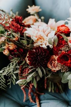 a bouquet of flowers sitting on top of a blue chair