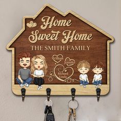 a wooden key holder with two keys hanging from it's sides and the words home sweet home on it