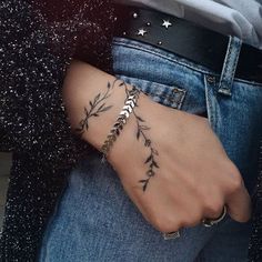 a woman's hand with a tattoo on it and stars in the sky behind her