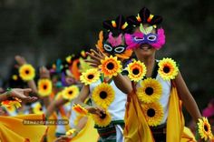 people in colorful costumes are dancing with flowers on their heads