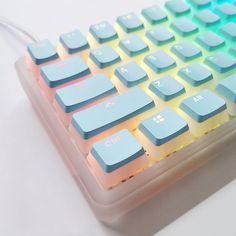 a close up of a keyboard on a white surface with blue keys and yellow letters