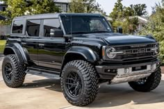 a black truck parked in front of a house