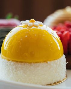 an egg on top of rice and other desserts sitting on a plate with strawberries in the background