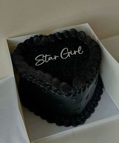 a heart shaped cake with the words star guide written on it sitting in a box