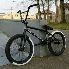 a black and white bike leaning against a wall