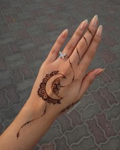 a woman's hand with henna tattoos on it and a diamond in the middle