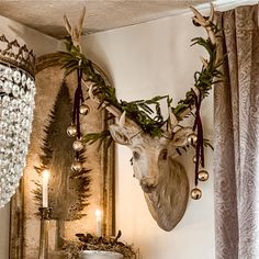 a deer head mounted on the wall next to a candle holder and other decorations in a living room