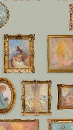 many paintings are hanging on the wall with gold frames