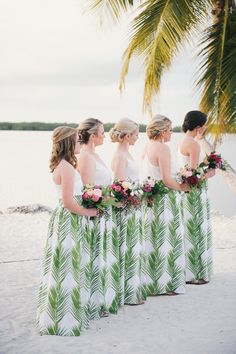 a group of women standing next to each other on top of a beach