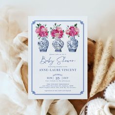 a baby shower with pink flowers in blue vases on the front and white background