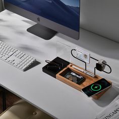 a desk with a keyboard, mouse and cell phone on it next to a computer monitor