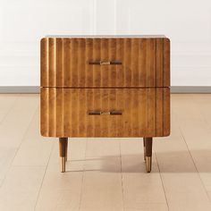 a wooden dresser sitting on top of a hard wood floor next to a white wall