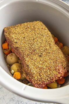 a pot roast with potatoes, carrots and other vegetables in the crockpot