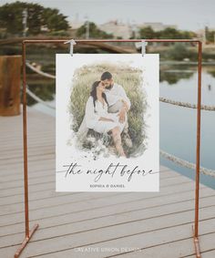 a wedding photo hanging on the side of a wooden dock