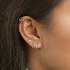 a woman wearing three different ear piercings