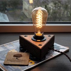 a light bulb sitting on top of a wooden block next to a window sill