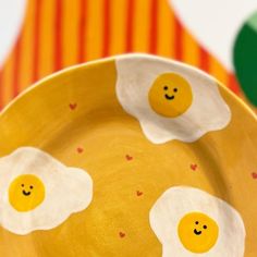 two fried eggs painted on a yellow plate