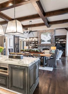 a large kitchen with an island in the center and two pendant lights hanging from the ceiling