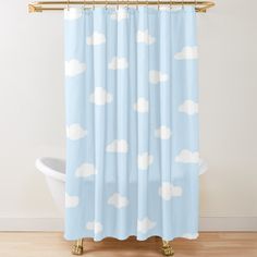 a blue shower curtain with white clouds in the sky on it and a gold rod