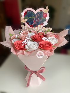 a bouquet of roses in a pink vase with a heart shaped card on top that says welcome