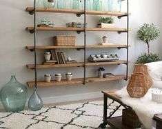 a living room filled with lots of shelves next to a white rug and vases