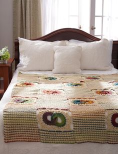 a bed with a white comforter and pillows on it in front of a window