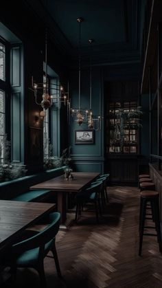 an empty restaurant with wooden tables and green chairs in front of large windows at night