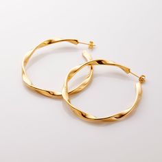 Our Ripple Hoop Earrings are inspired by the ripple effect that a pebble can cause in the ocean - these hoops stand as a reminder that you can have a ripple effect on the world with even the smallest action. Materials & Warranty Material: Real 18 karat gold plating on pure stainless steel Hypoallergenic | Sensitive Skin-Friendly Warranty: Lifetime Warranty against all rust or tarnish Packaging: Nominal Velvet Drawstring Pouch Earrings cannot be returned or exchanged due to hygienic safety