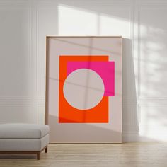 an orange and pink square with a white circle in the center on a light wood floor