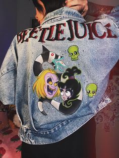 - Bettlejuice and Lydia - One of a kind custom hand painted jackets made with love  by 100% fabric paint! - Item Details: Hand painted secondhand oversize midwash blue denim jacket reworked with fabric paint with Beetlejuice and Lydia cartoon art. The fabric content is 100% cotton. - Size Details: Measurements: Chest: 40 cm Length: 56 cm Waist: 40 cm There may be deviation of 2-3 cm. Cleaning Instructions: -hand wash only, line dry -no bleach, no dryer, no iron Made by Yumiko Exchanges and retur Blue Hand Painted Denim Jacket For Streetwear, Hand-painted Blue Denim Jacket, Blue Hand Painted Denim Jacket, Hand Painted Cotton Denim Jacket For Streetwear, Lydia Cartoon, Lydia Beetlejuice Cartoon, Emo Hoodie, Jean Oversize, Lydia Beetlejuice